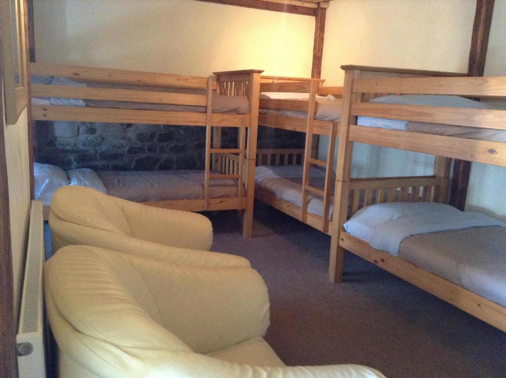 a room with three bunk beds and a couch at Pantyrathro International Hostel in Carmarthen
