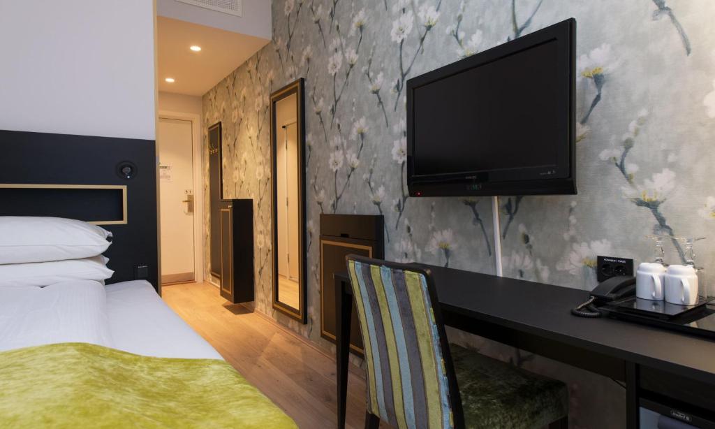 a hotel room with a bed and a flat screen tv at Thon Hotel Opera in Oslo