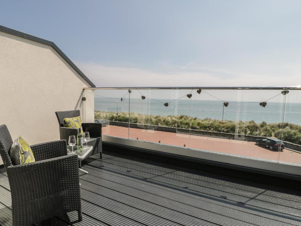 a balcony with chairs and a view of the ocean at Welymora in Pwllheli