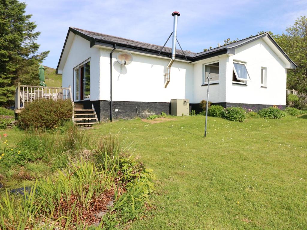 a white house with a grass yard at Westhaven in Mallaig