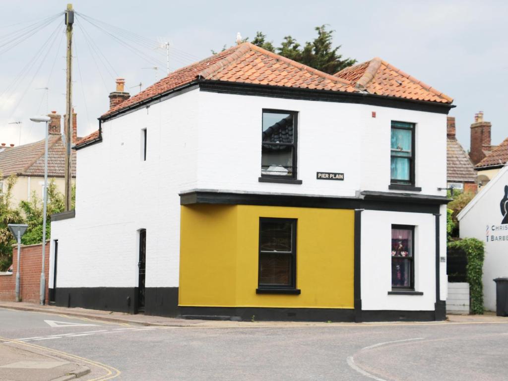 ein weißes und gelbes Haus an der Ecke einer Straße in der Unterkunft Rose Cottage in Great Yarmouth