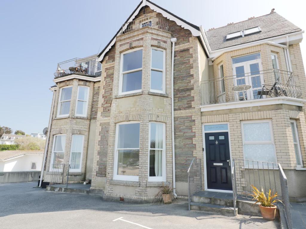 una casa de ladrillo marrón con puerta negra en Seashore House, en Newquay