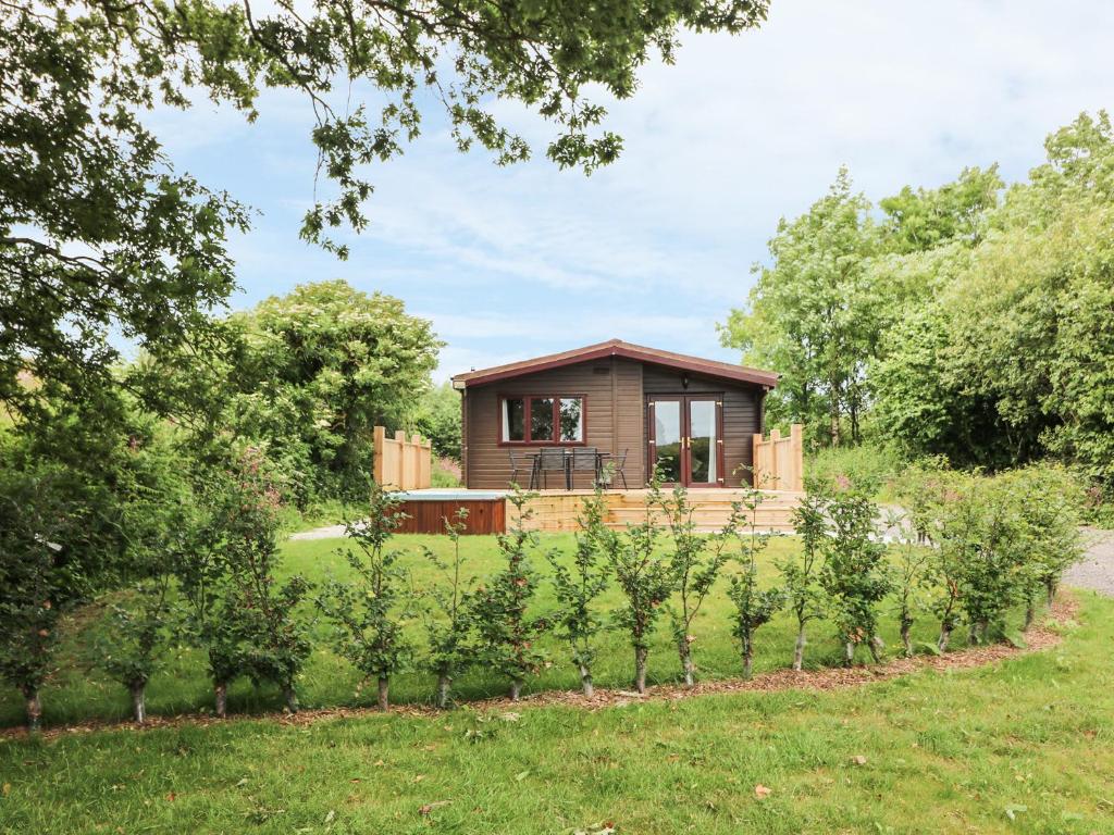 a small cabin in the middle of a garden at Oak Lodge in Falmouth