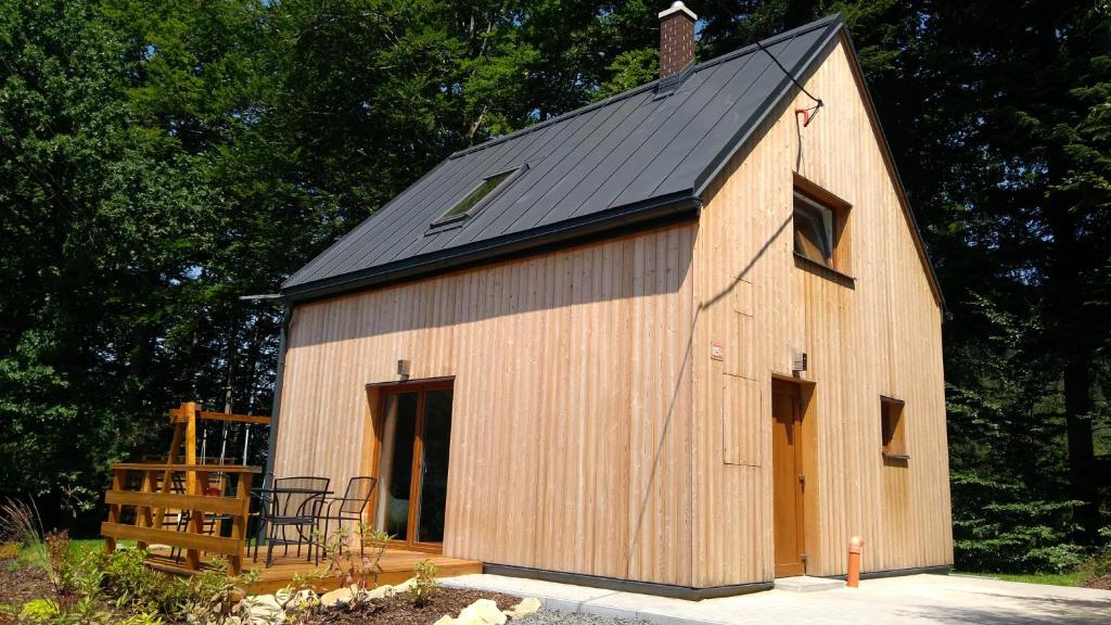 a large wooden barn with a black roof at Chata na sjezdovce in Malenovice