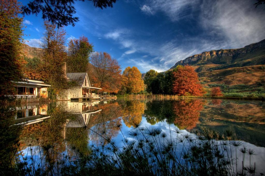 a reflection of a house on a lake in the mountains at Cleopatra Mountain Farmhouse in Fort Nottingham