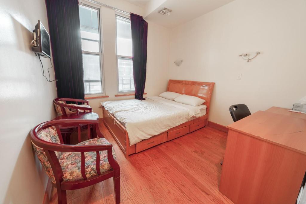 een kleine slaapkamer met een bed en een raam bij U.S. Pacific Hotel in New York