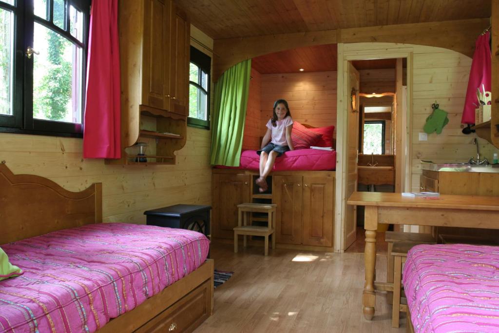 a woman sitting on a bed in a room at La Maison de l'Omignon in Vermand