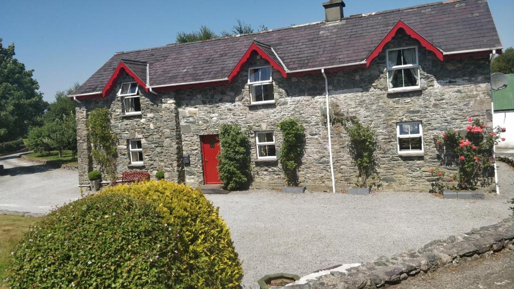 una grande casa in pietra con una porta rossa di Tig Rua a Killarney