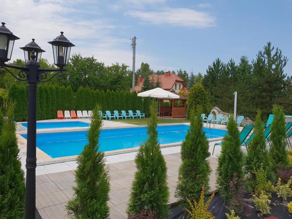 una piscina con sillas y un poste de luz en Pokoje Irys en Kazimierz Dolny