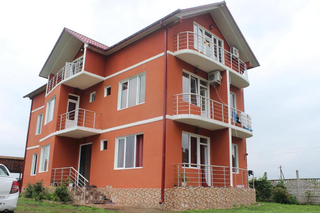 un edificio rojo con balcones blancos. en Hotel Ureki, en Ureki