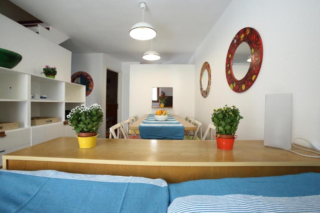 Casa Arcobaleno Carloforte في كارلوفورتي: غرفة معيشة مع طاولة وغرفة طعام