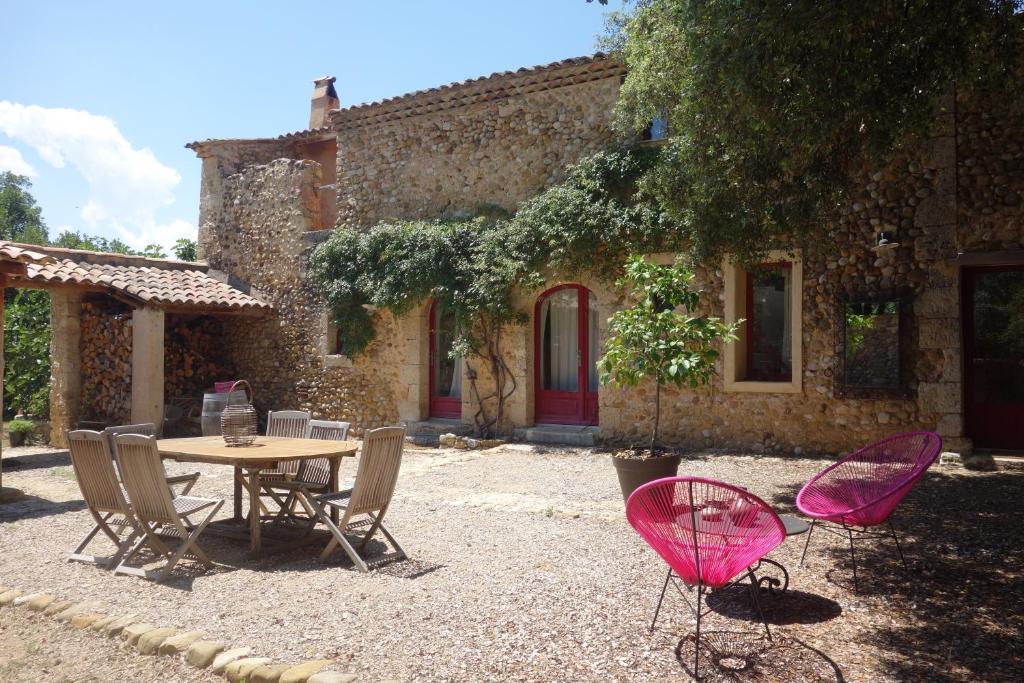 une table et des chaises devant une maison dans l'établissement Le clos des collines, à Saint-Martin-de-Brômes