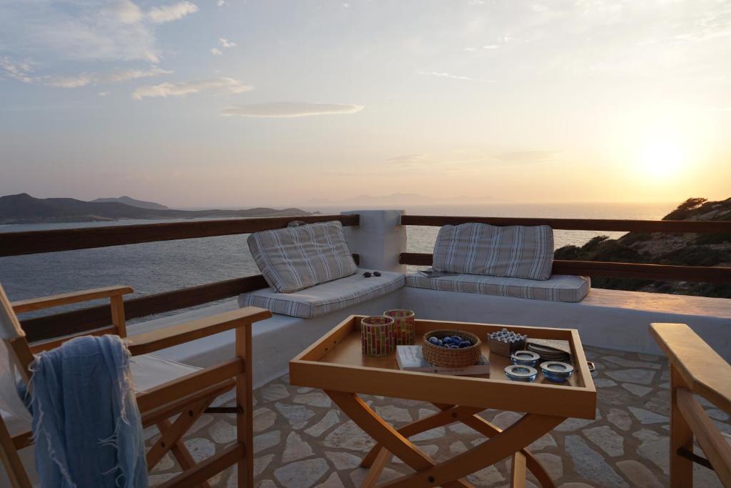 a balcony with a table and chairs and the ocean at Antiparos Vibes in Agios Georgios
