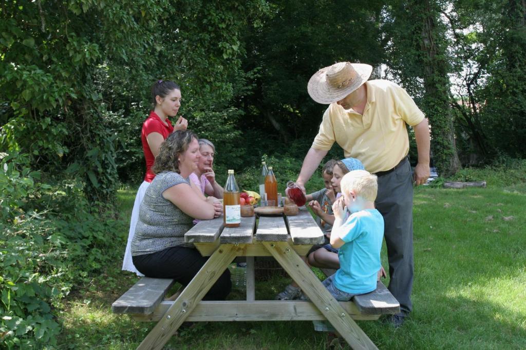 a group of people sitting around a picnic table at La Maison de l'Omignon in Vermand