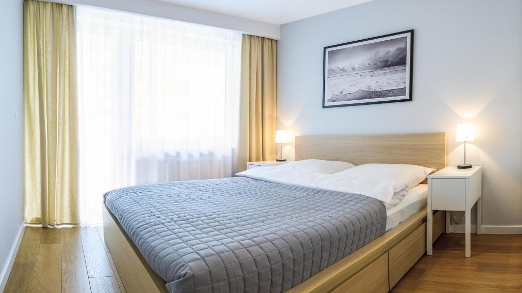 a bedroom with a bed and a large window at FARO Apartamenty Bliżej Morza in Kołobrzeg