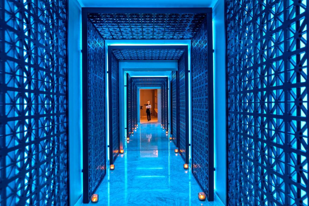 a hallway in a blue building with a person walking down it at Four Seasons Hotel in Limassol
