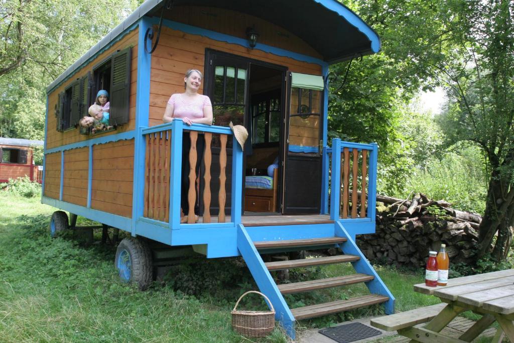 a woman standing on the porch of a play house at La Maison de l'Omignon in Vermand
