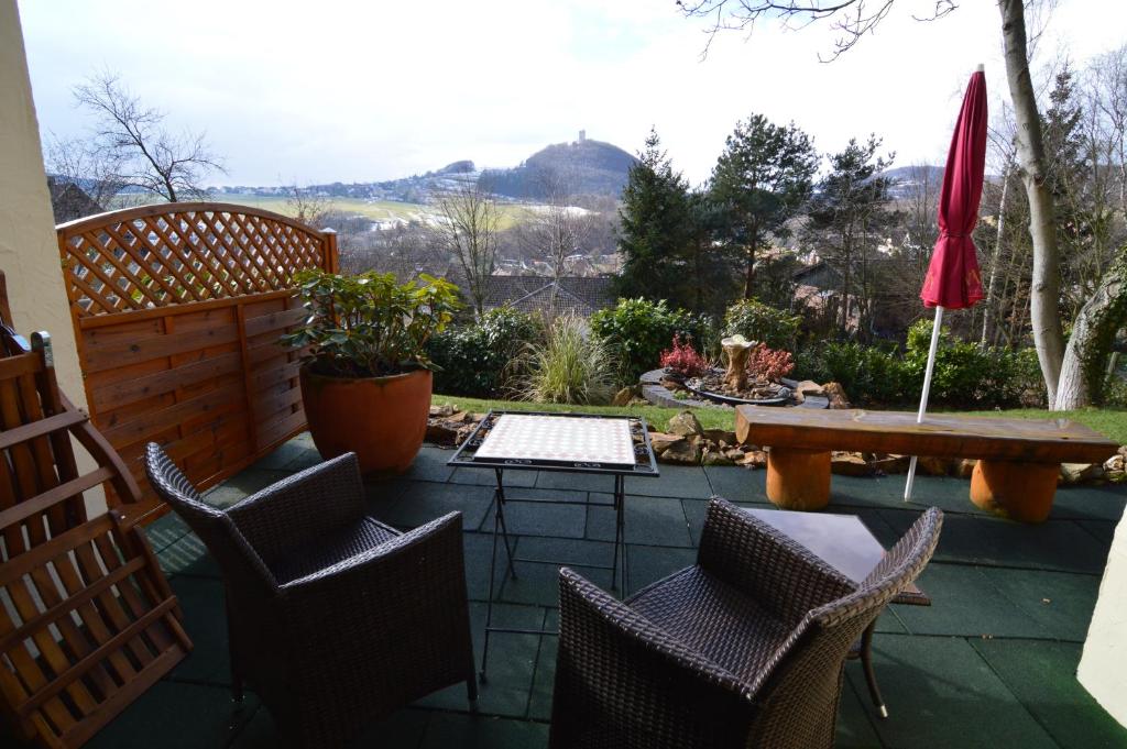 een patio met stoelen, een tafel en een parasol bij Landhotel Maarheide in Niederdürenbach