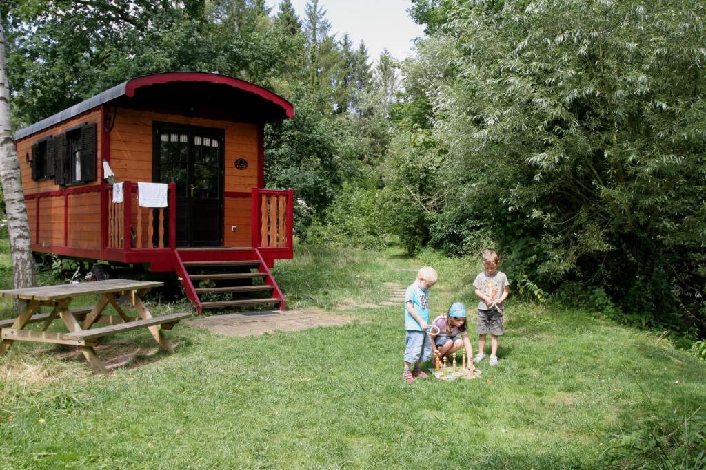 a group of people standing in the grass near a tiny house at La Maison de l'Omignon in Vermand