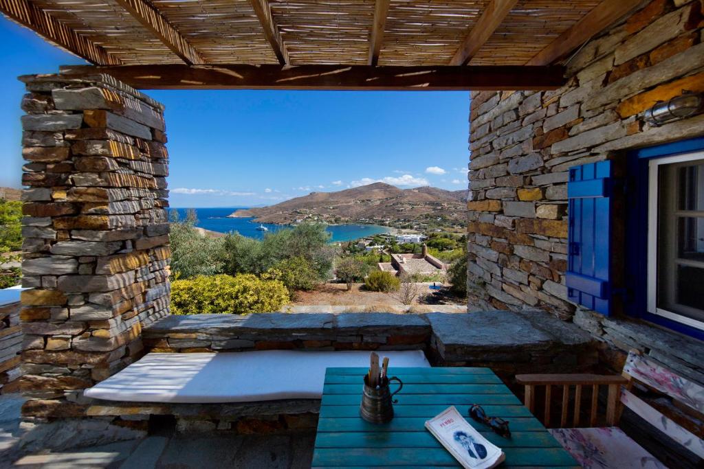 a patio with a table and a view of the water at Stone house with a magical view in Otziás