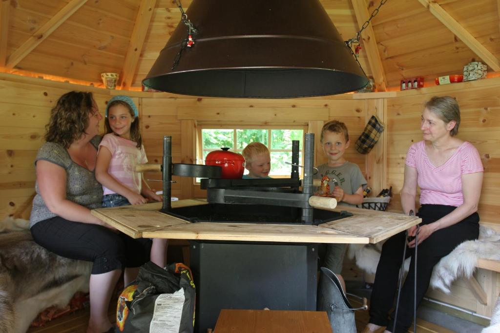 a group of people standing around a stove in a cabin at La Maison de l'Omignon in Vermand