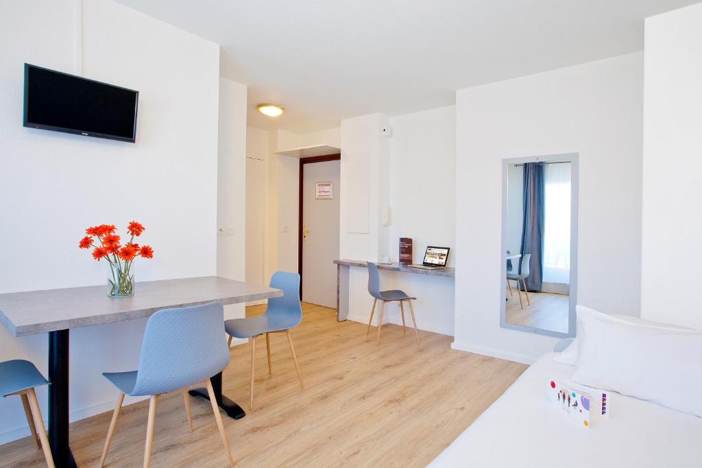 a dining room and living room with a table and chairs at Cerise Lannion in Lannion