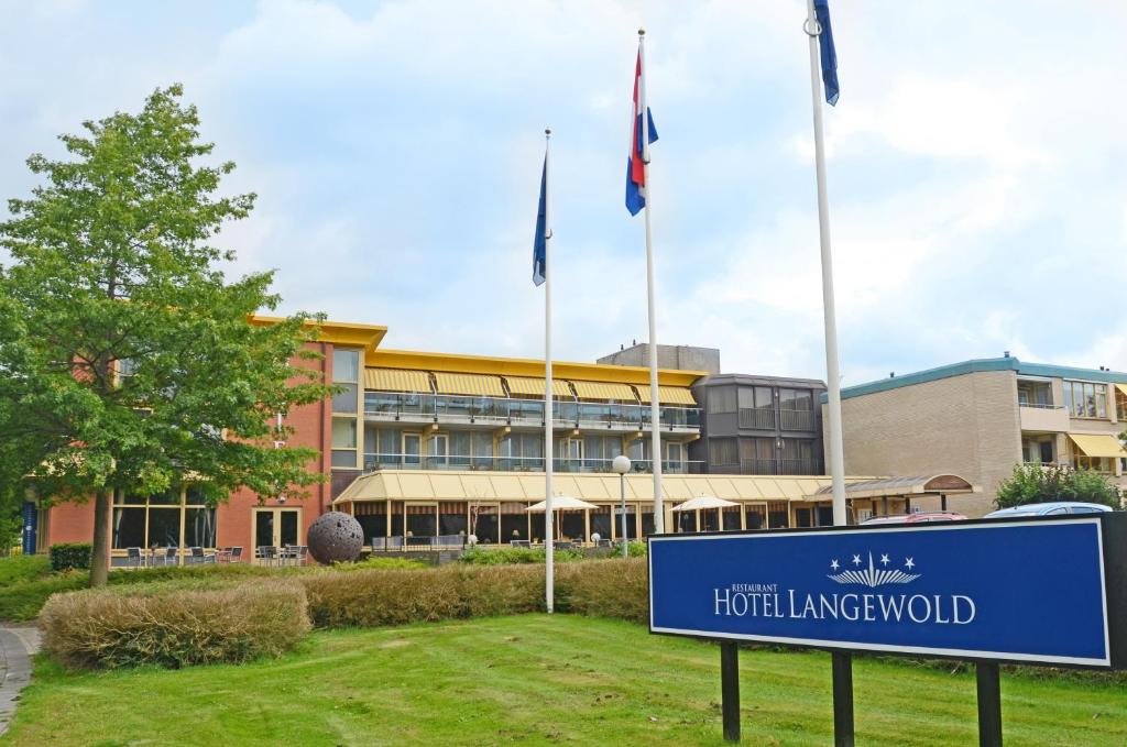 een blauw bord voor een gebouw met vlaggen bij Fletcher Hotel-Restaurant Langewold in Roden