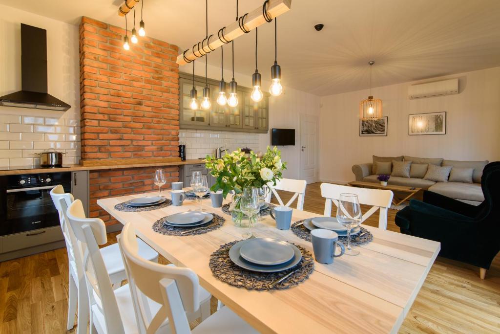 kuchnia i salon ze stołem i krzesłami w obiekcie Apartamenty Rydzewo w Rydzewie