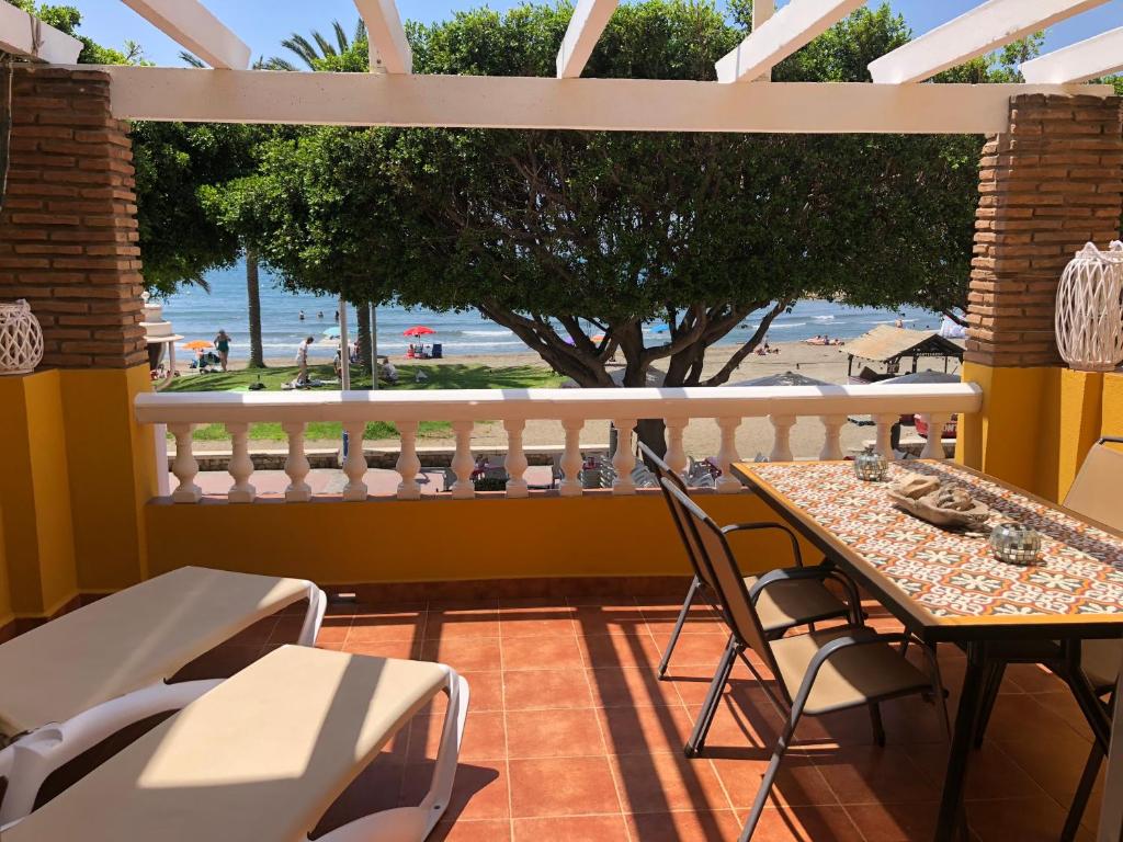 balcone con tavolo, sedie e vista sulla spiaggia di Aunt Antonia Beach House a Málaga