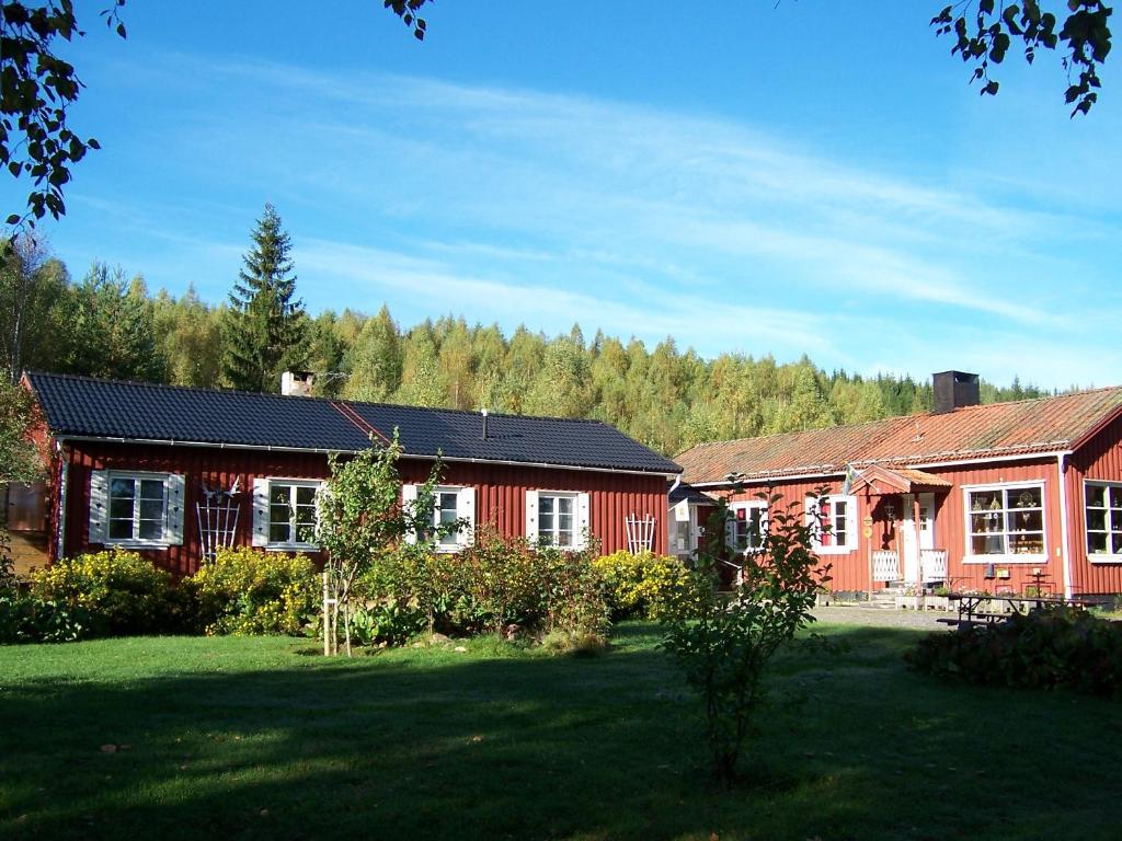 una casa roja con un patio delante en Nya Skogsgården Hostel, en Torsby