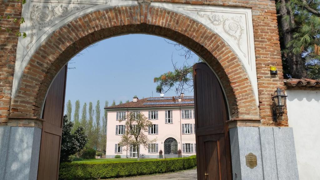 an archway leading to a large white building at B&B La Cascina Grossa in Alessandria