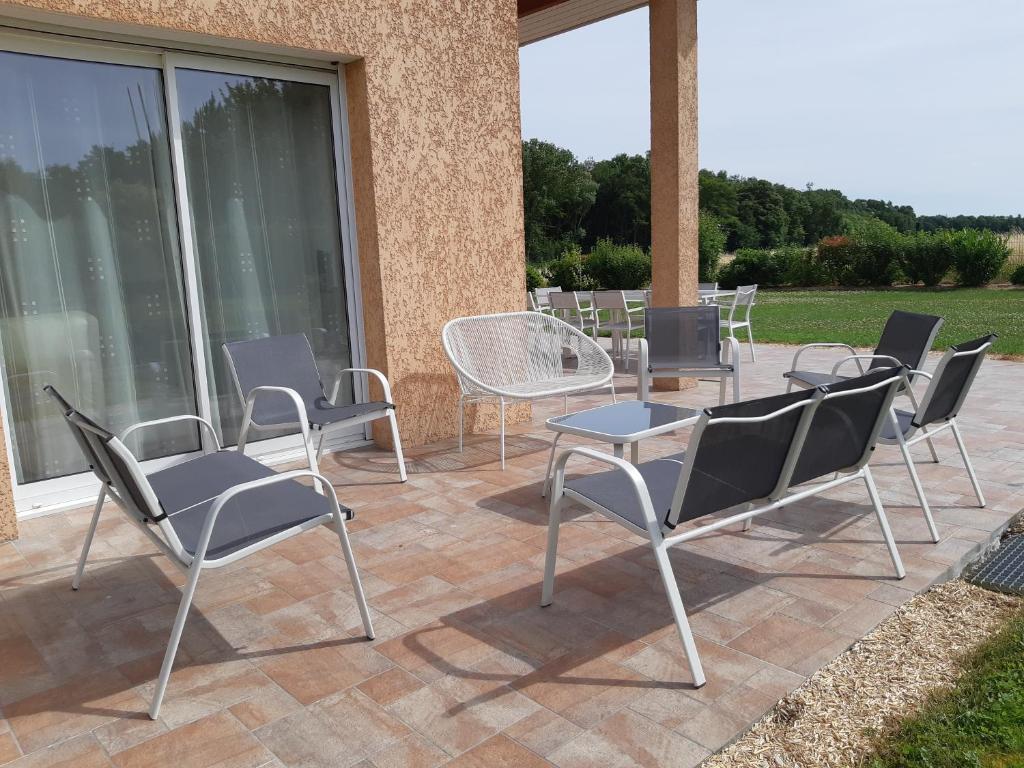 grupa krzeseł i stołów na patio w obiekcie Ma Deuxieme Maison en Champagne à ECURY SUR COOLE w mieście Écury-sur-Coole
