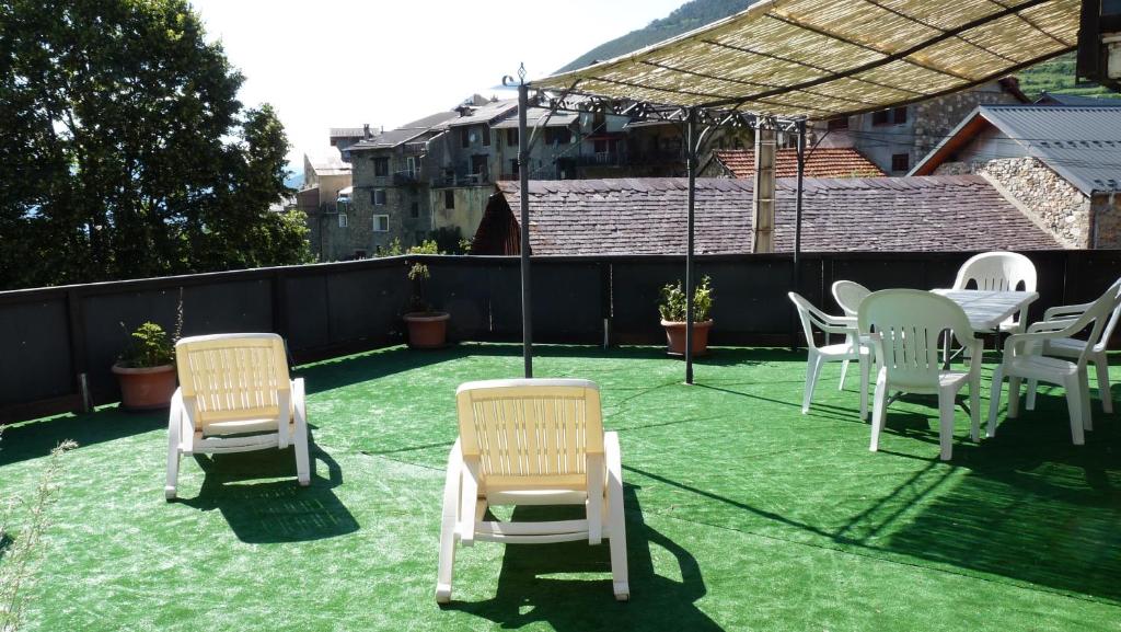 eine Gruppe von Stühlen und Tischen auf einer Terrasse in der Unterkunft Chalet Le Bois Noir in Valdeblore