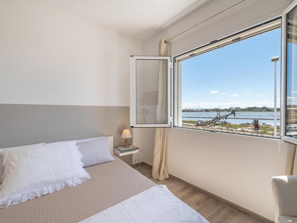 ein Schlafzimmer mit einem Bett und einem großen Fenster in der Unterkunft Panoramic Studio Carloforte in Carloforte