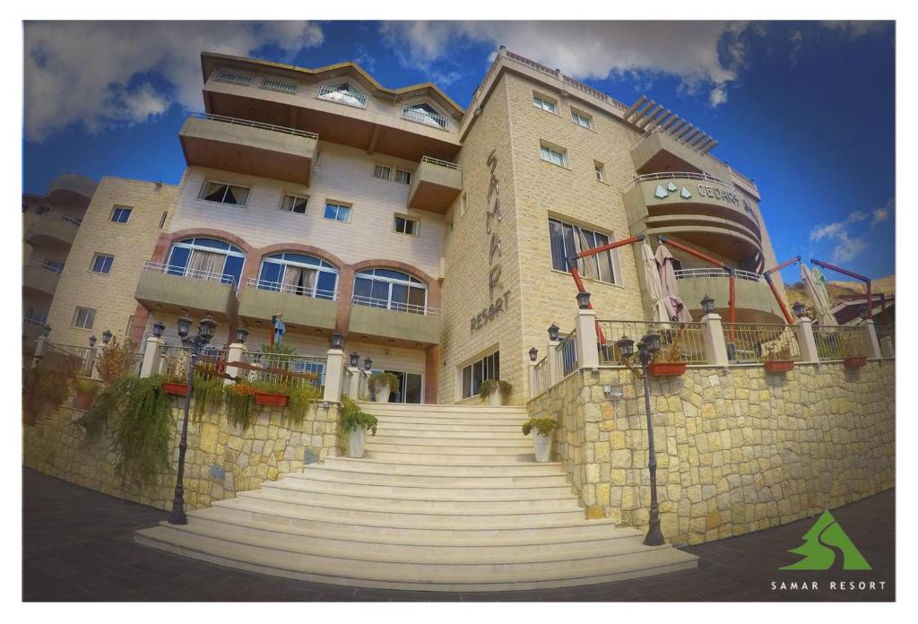 a large building with stairs in front of it at Samar Resort Aparthotel in Bcharré