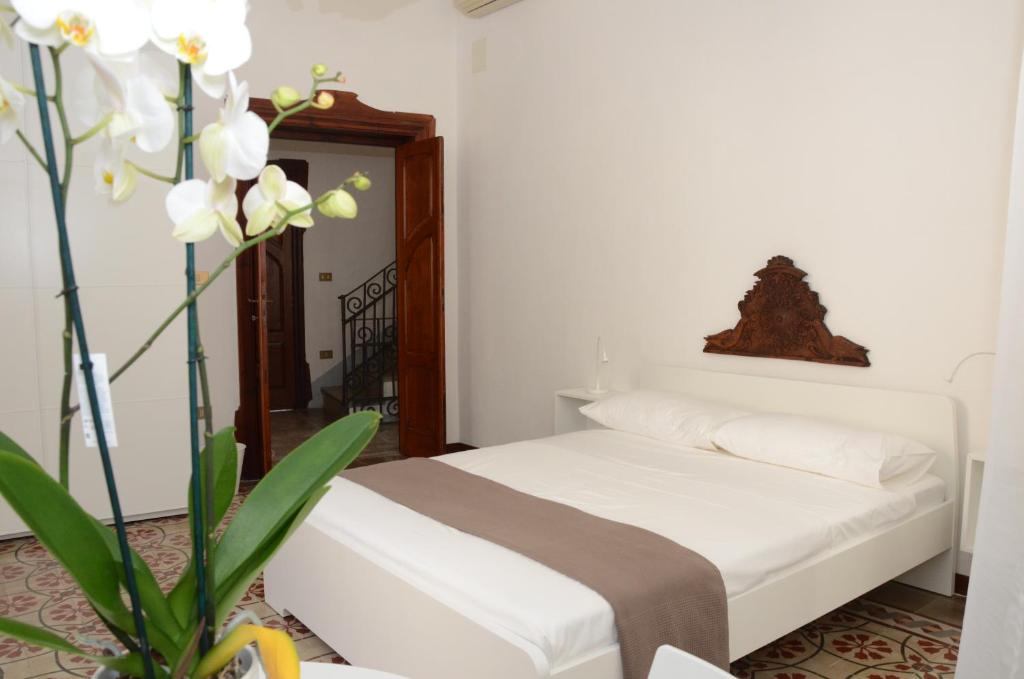 una camera con letto e vaso con fiori bianchi di Casa Cabras a Siniscola