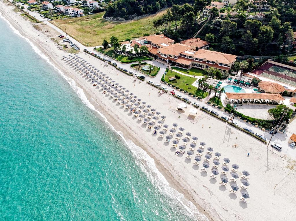 una vista aérea de una playa con sombrillas y el océano en Possidi Holidays Resort & Suite Hotel, en Possidi