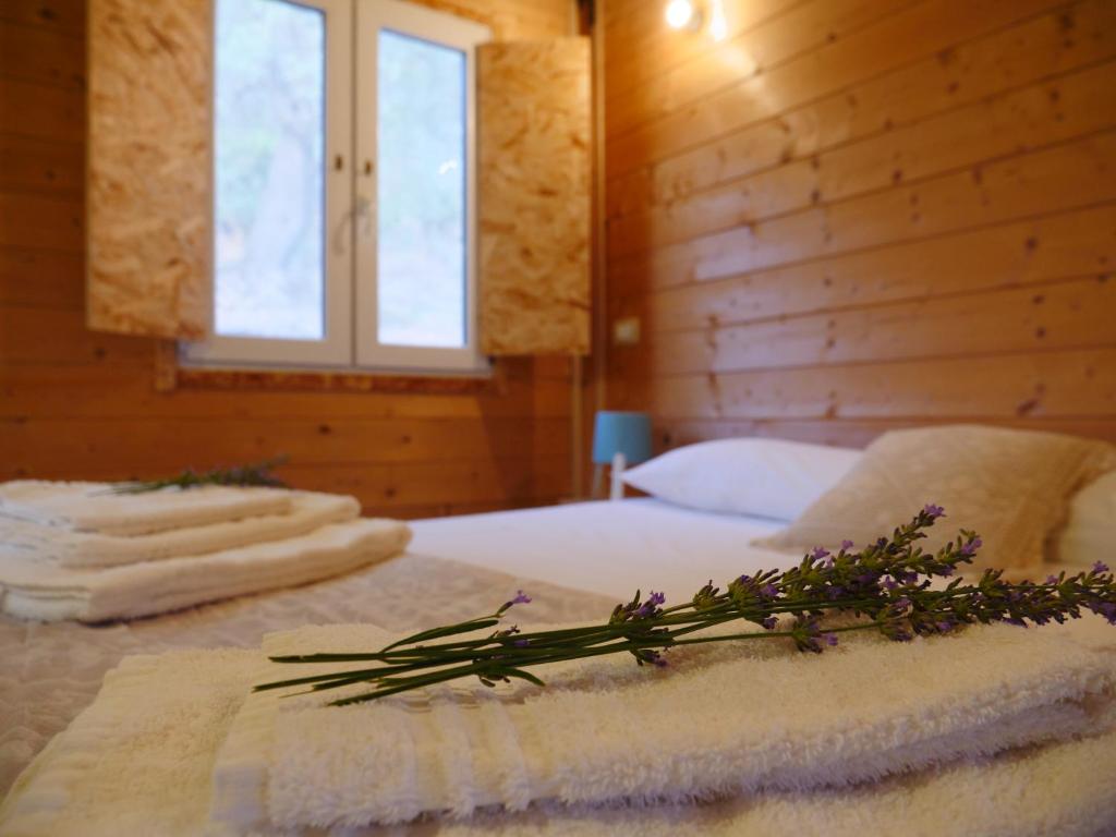 a bedroom with a bed with a flower arrangement on it at Camping Fiori di Noto in Noto