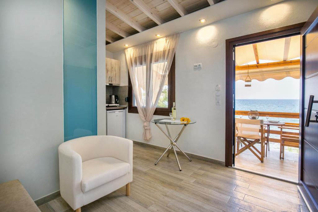 ein Wohnzimmer mit einem weißen Stuhl und Meerblick in der Unterkunft Romantic Apartment in Skala Kallirachis