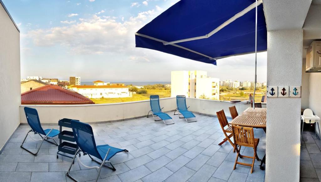 um pátio com uma mesa e cadeiras no telhado em Axa apartment em Mamaia Nord – Năvodari