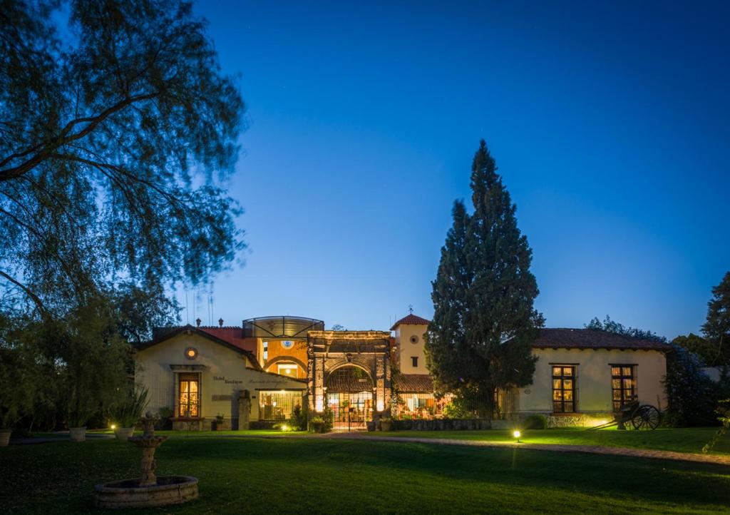 una casa grande con un patio iluminado por la noche en Hacienda La Magdalena, en San Francisco Tesistán