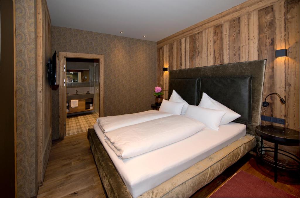 a bedroom with a large white bed in a room at Postresidenz in Mayrhofen