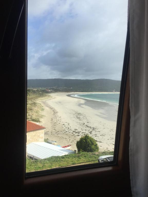 a view of a beach from a window at Pension Doña Lubina in Finisterre