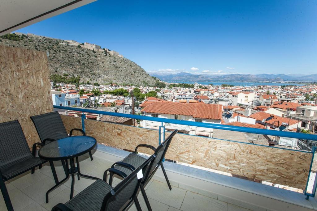 a balcony with chairs and a view of a city at Vista Del Mare Rooms in Nafplio