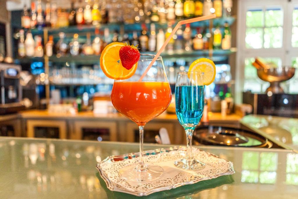 two cocktails sitting on a counter in a bar at Boat Hotel De Barge in Bruges