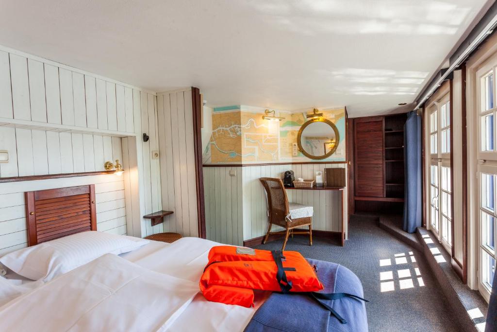 a bedroom with a bed and a desk with a chair at Boat Hotel De Barge in Bruges