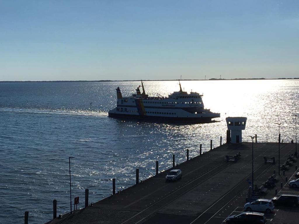 un gran barco en el agua junto a un muelle en Pension Peterswarft en Dagebüll