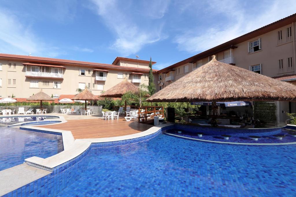 um resort com uma piscina com um grande edifício em Hotel Mantovani em Águas de Lindoia
