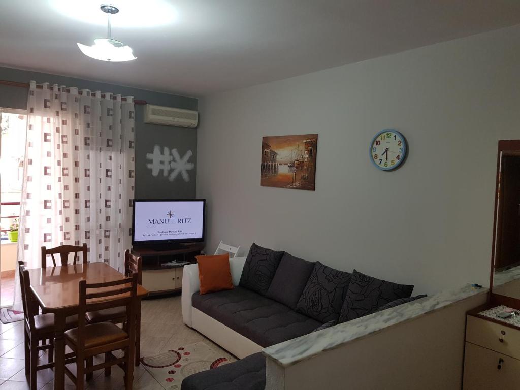 een woonkamer met een bank, een tafel en een tv bij Apartament Joni in Golem