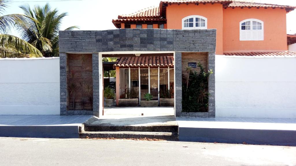 un edificio con un muro bianco e un edificio di Maison Aires Malcher a Maricá